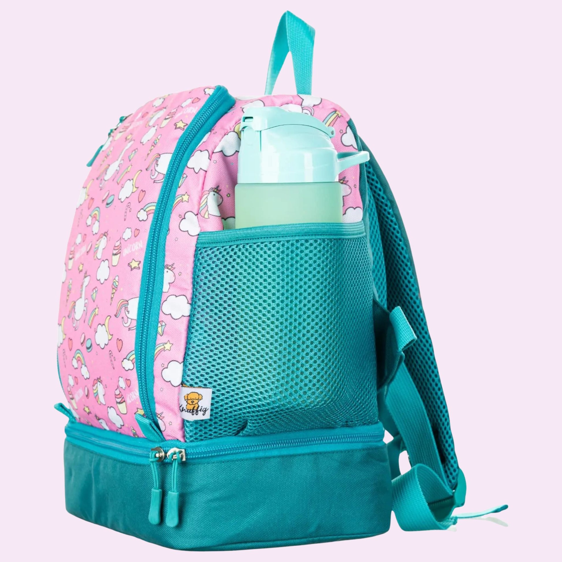 Die Seitenansicht eines blauen Kinderrucksacks zeigt deutlich die elastische Netztasche an der Außenseite, in der eine bunte Trinkflasche sicher verstaut ist. Der Rucksack steht auf einem Holzboden, und das Profil hebt die gepolsterten Schultergurte und den robusten Reißverschluss des Hauptfachs hervor. Die Flasche ist griffbereit platziert, was die Funktionalität für Ausflüge unterstreicht.