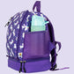 Detailansicht der rechten Seite des lila Einhorn-Kinderrucksacks. Im Fokus steht das elastische, dunkellila Netzfach, das eine Trinkflasche sicher umschließt. Der Hintergrund zeigt den hochwertigen, lilafarbenen Stoff mit dezentem Sternen-Print. Die Aufnahme verdeutlicht, wie einfach Kinder ihre Erfrischung griffbereit haben, ohne das Hauptfach öffnen zu müssen, und unterstreicht die praktische Organisation für den Kindergartenalltag.