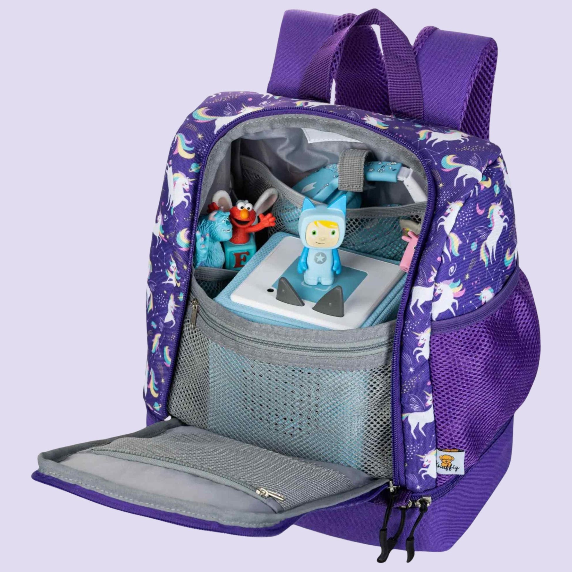 Eine seitliche Perspektive in das weit geöffnete Hauptfach des lila Einhorn-Rucksacks. Man sieht die Toniebox, die stabil im Fach steht, sowie mehrere Tonie-Figuren, die in elastischen Schlaufen an der Innenseite aufgereiht sind. Diese Ansicht verdeutlicht, wie kompakt und sicher das Audio-System verstaut ist, während die Figuren für das Kind jederzeit griffbereit bleiben. Das glitzernde Sternenmuster des lila Stoffes umrahmt das organisierte Innenleben.