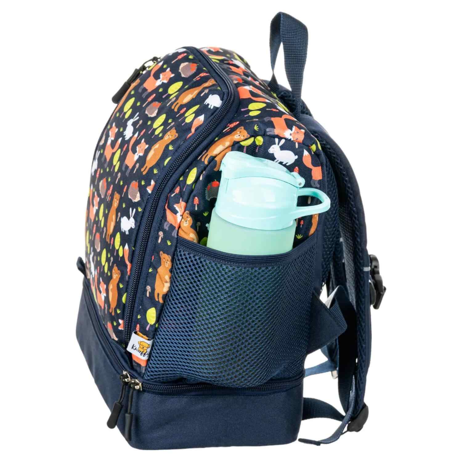 Ein knuffiger blauer Kinderrucksack mit einem niedlichen Fuchs-Design in der Seitenansicht. Der Rucksack zeigt eine praktische elastische Netztasche an der Seite, in der eine Trinkflasche steckt. Das Design umfasst herbstliche Waldmotive und kindgerechte Details auf strapazierfähigem blauem Stoff.