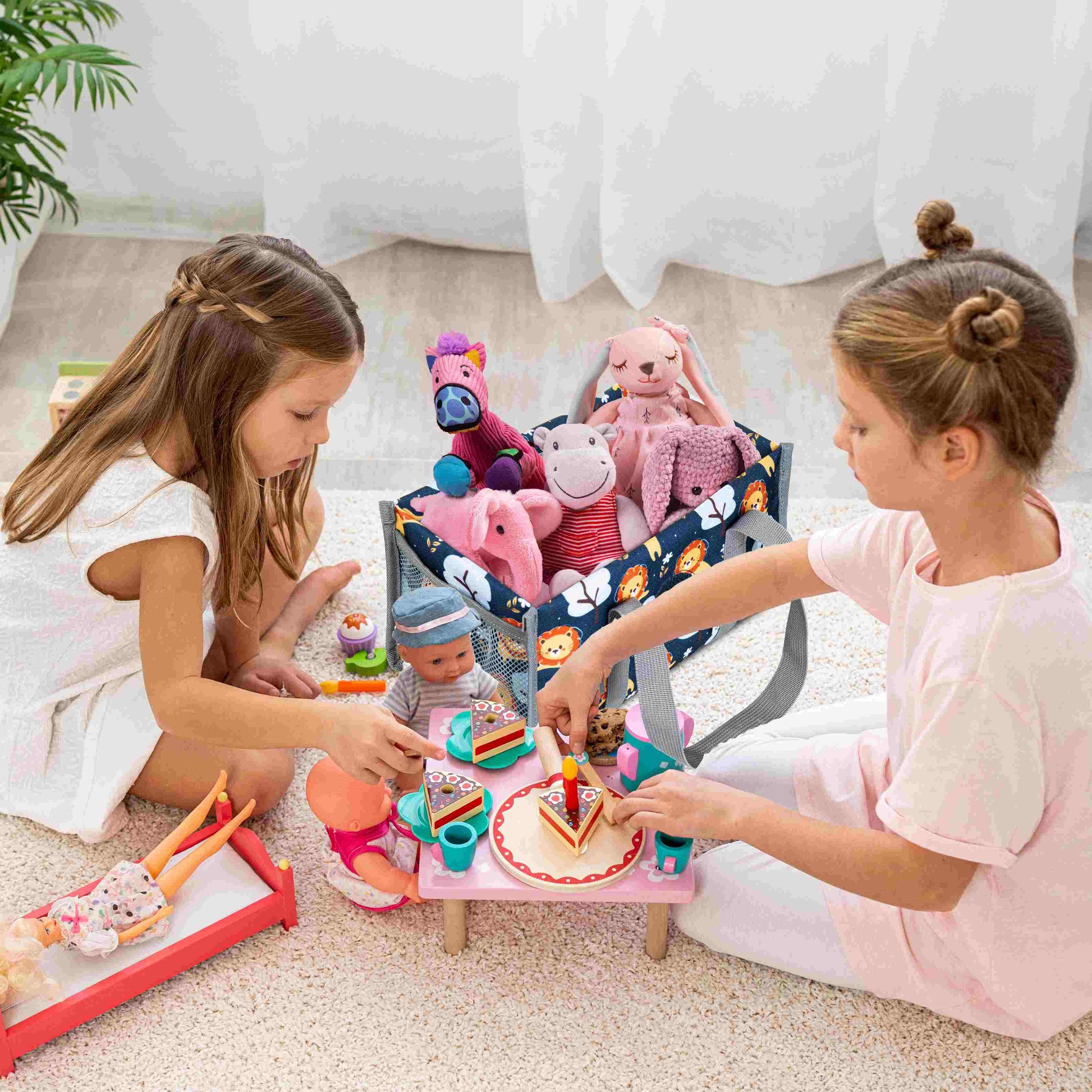 Zwei fröhliche Mädchen sitzen nebeneinander und teilen ihre Spielsachen im Zimmer