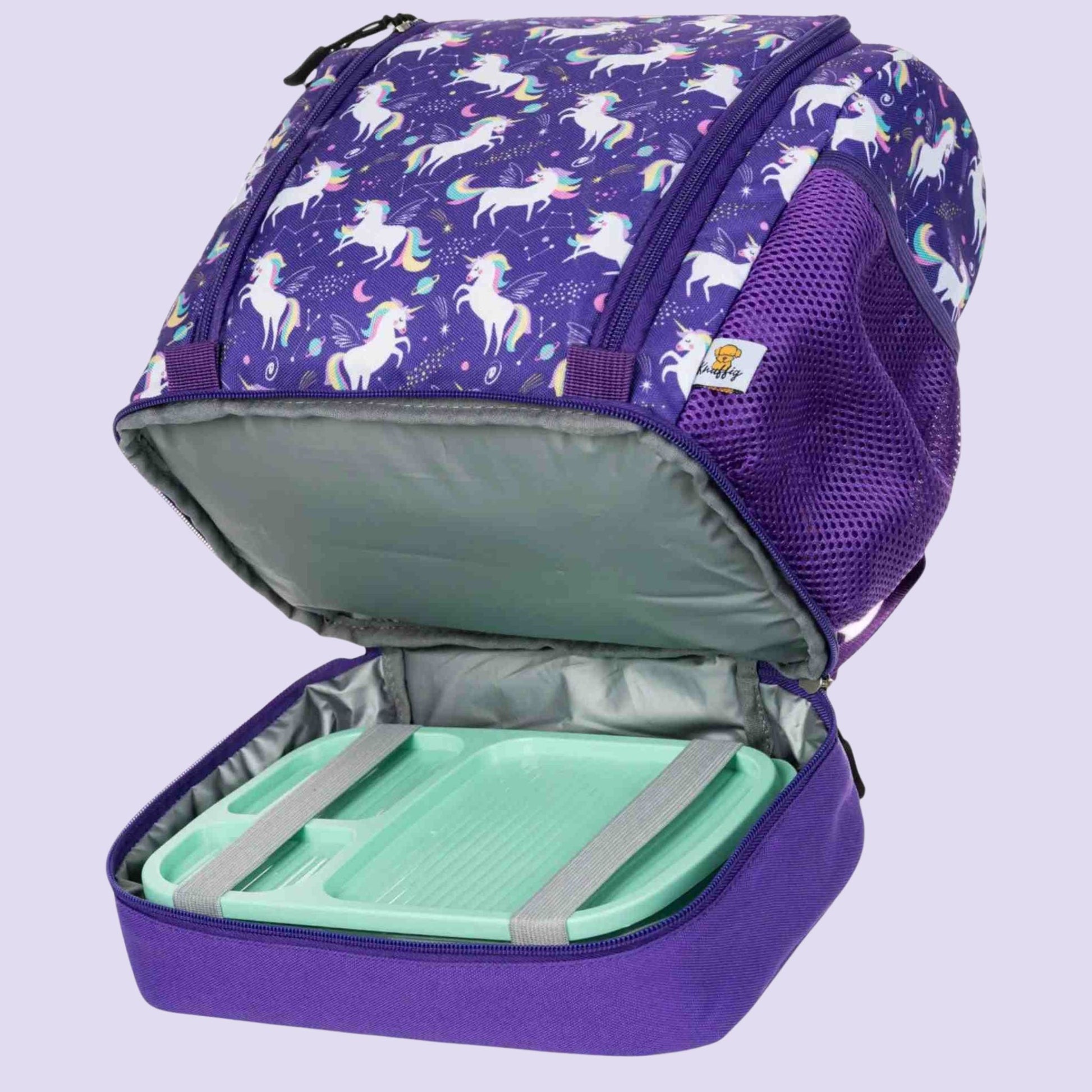 Eine Nahaufnahme des geöffneten Vorderfachs eines lila Einhorn-Rucksacks. Im Inneren ist eine Brotdose zu sehen, die durch integrierte elastische Gummibänder fest an ihrem Platz gehalten wird. Diese praktische Befestigung verhindert, dass die Lunchbox im Rucksack hin- und herrutscht oder umkippt. Das durchdachte Design sorgt für Ordnung und schützt den restlichen Tascheninhalt vor ungewolltem Auslaufen oder Krümeln.