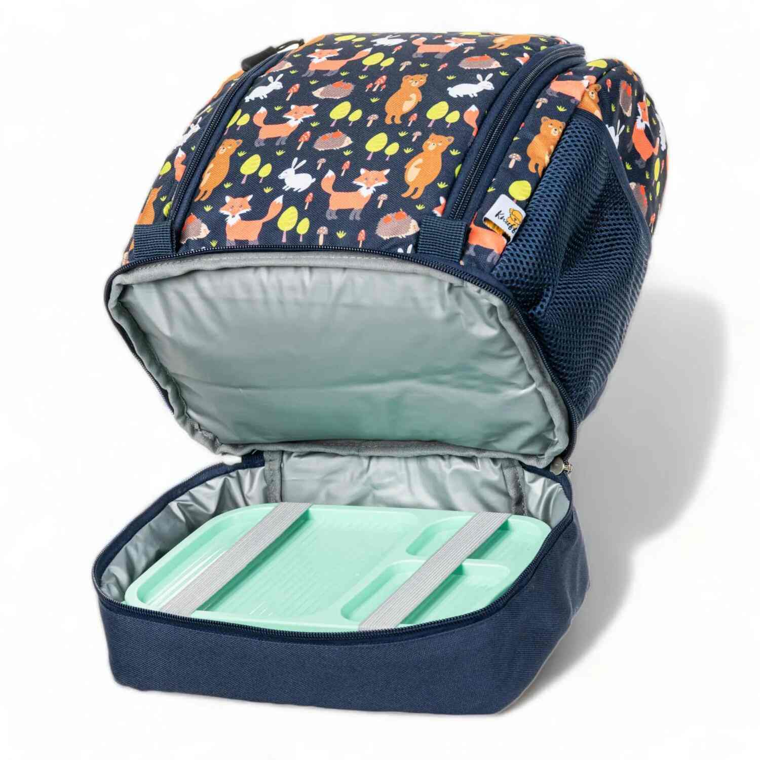 Nahaufnahme des geöffneten Hauptfachs eines blauen Kinderrucksacks. Im Inneren ist ein spezielles, silberfarbenes Isolierfach sichtbar, in dem eine farbenfrohe Lunchbox verstaut ist. Die Abbildung verdeutlicht die Thermofunktion des Rucksacks, die Mahlzeiten frisch hält.