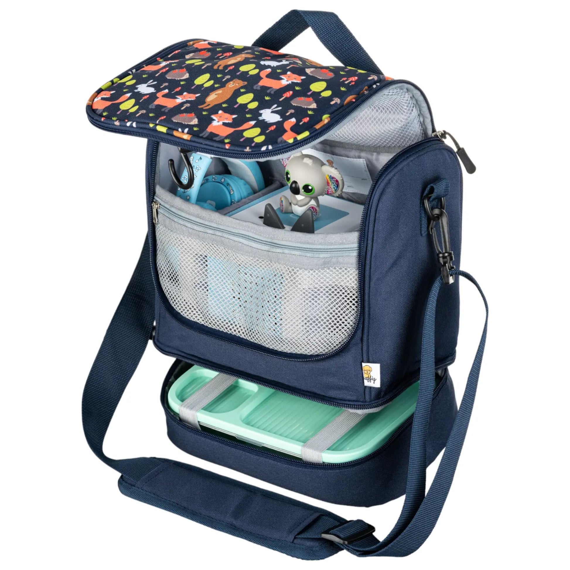 Die geöffnete Umhängetasche zeigt das durchdachte Innenleben: Im oberen Bereich ist eine Toniebox verstaut, während im separaten, isolierten Bodenfach eine Lunchbox Platz findet.
