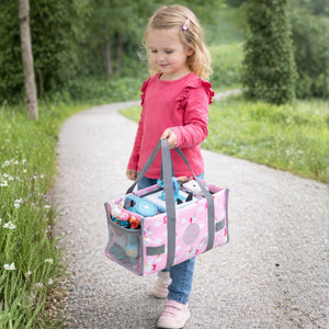 Ein kleines Mädchen trägt die rosa Einhorn-Transporttasche am praktischen Handgriff; ideal zum einfachen Mitnehmen der Toniebox und der Lieblingsfiguren auf Reisen oder zu Freunden.
