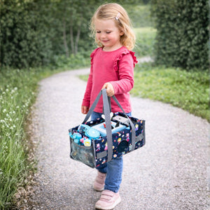 Ein kleines Mädchen hält die rosa Prinzessinnen-Tragetasche am verstärkten Handgriff; das liebevolle Design und die kindgerechte Größe machen sie zum idealen Accessoire für kleine Fans und den sicheren Transport der Toniebox.
