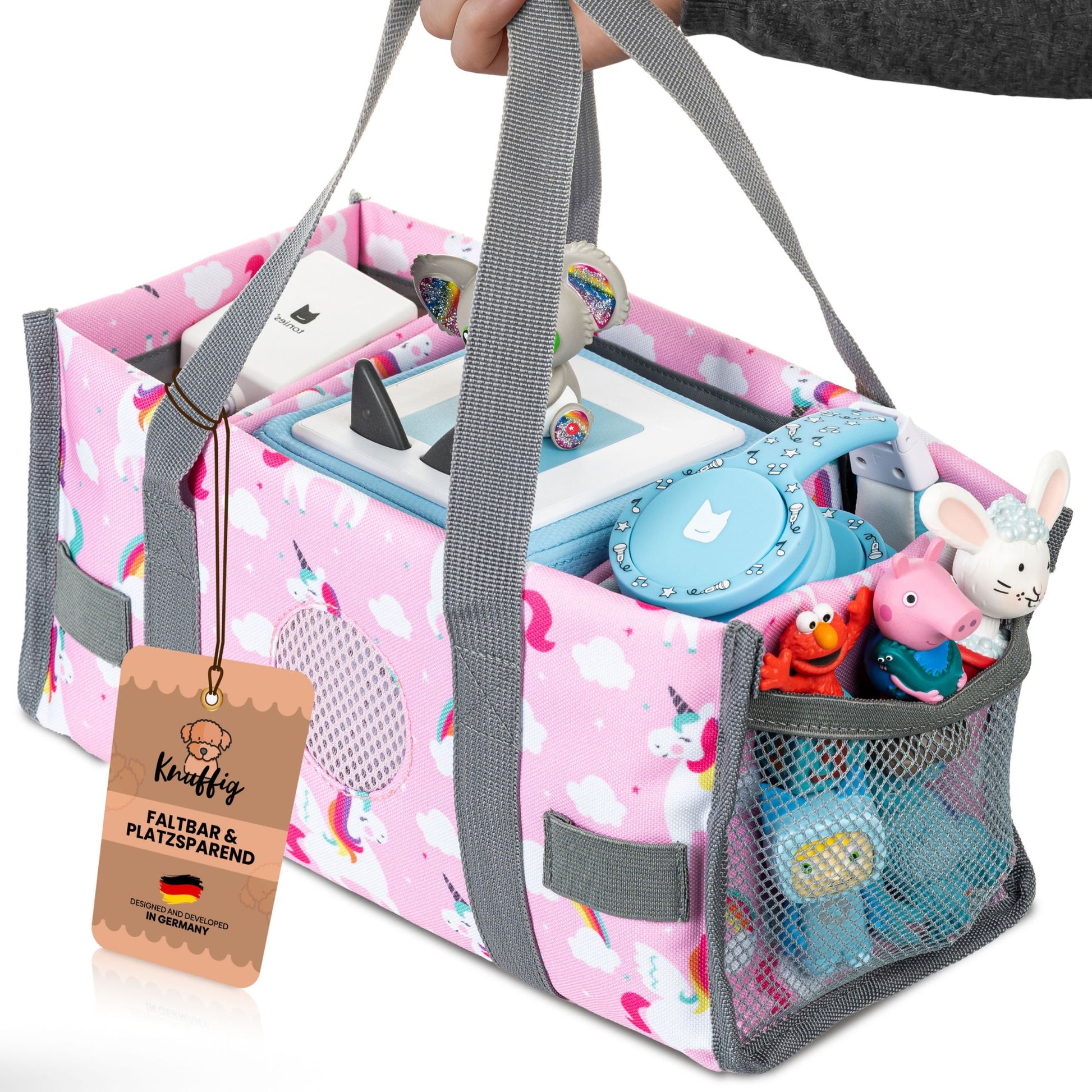 Ein kleines Mädchen hält die rosa Einhorn-Tragetasche am bequemen Griff in der Hand; die Tasche ist mit der Toniebox und zwei Tonie-Figuren gefüllt und zeigt, wie einfach Kinder ihre Hörspielwelt überallhin mitnehmen können.